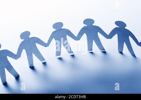 Persone di carta in piedi insieme mano in mano. Team, società, business concept Foto Stock