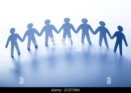 Persone di carta in piedi insieme mano in mano. Team, società, business concept Foto Stock