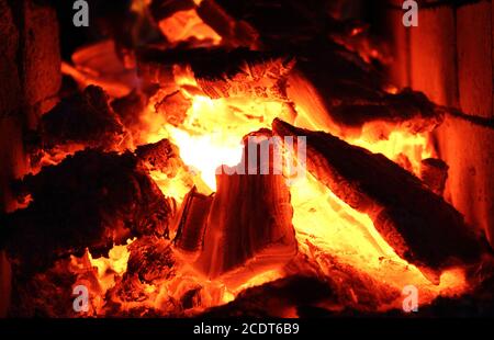 Legna da ardere, calici caldi e fuoco nel camino Foto Stock