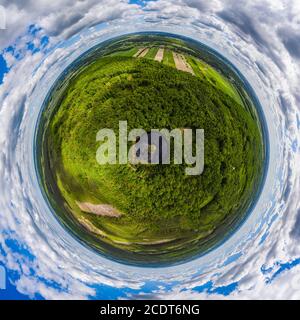 Round lake with island in the middle among forest, little planet aerial view Foto Stock