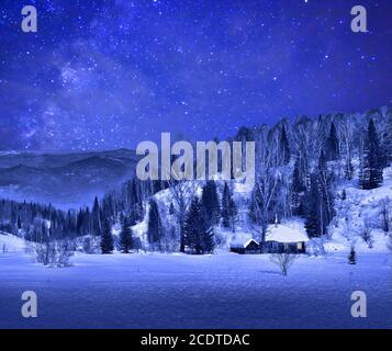 Piccola casa di legno in un paesaggio di montagna invernale notte Foto Stock