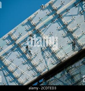 Montatori su un tetto in vetro in un cantiere in Berlino Foto Stock