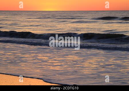 Il bagliore arancione del sole che comincia a sorgere sopra l'Oceano Atlantico ad Avalon, New Jersey, USA Foto Stock