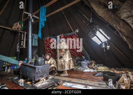 Un giovane Nenet all'interno di un chum (tenda tradizionale coperta di pelli di renna), Yamalo-Nenets Autonomous Okrug, Russia Foto Stock