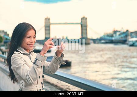 Londra donna turista scattare foto di Tower Bridge con fotocamera mobile smartphone. Ragazza che gode di vista sul Tamigi, Londra, Inghilterra, Great Foto Stock