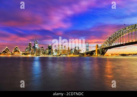 Tramonto colorato e scuro nella città di Sydney, dal porto di fronte allo skyline del CBD. Foto Stock