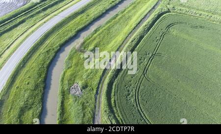 La vista dall'alto del campo di grano e del canale del sistema di irrigazione. Ripresa da un drone. Foto Stock