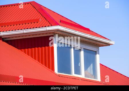 Casa con finestre in plastica e un tetto rosso del foglio ondulato Foto Stock