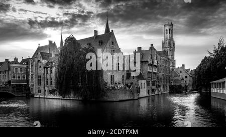 Foto in bianco e nero degli edifici storici e della Torre Belfort vista dal canale Dijver nella città medievale di Bruges, Belgio Foto Stock