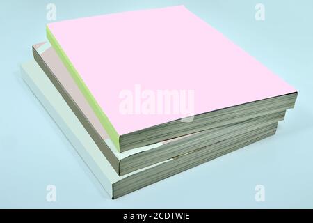 Pila di tre spesse riviste o libri, cataloghi con copertina rosa vuota Foto Stock