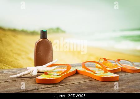 Accessori per prendere il sole collocati su tavole di legno in spiaggia Foto Stock