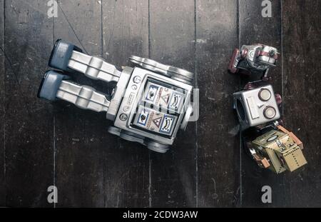 supporto tecnico concept; con un team di robot vintage che riparano i grandi robot Foto Stock