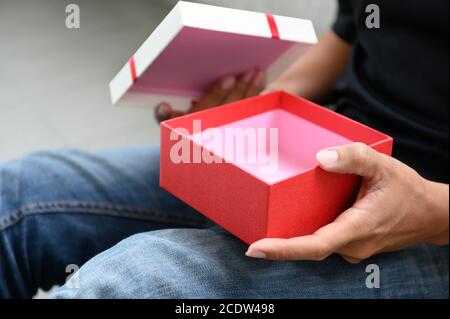 Uomo che apre una confezione regalo vuota. Foto Stock