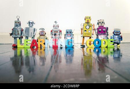 CODICE DI APPRENDIMENTO lettere in legno e giocattoli robot retrò Foto Stock