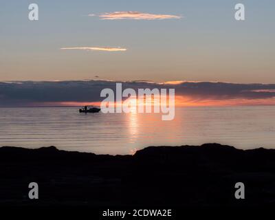 Il sole tramonta su Port Phillip Bay, Mount Eliza, Australia. Pescatori silhouetted. Foto Stock