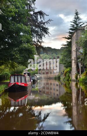 Narrowboat e tessitori cottage riflessi nel canale Rochdale, Hebden Bridge, Pennines, Yorkshire Foto Stock