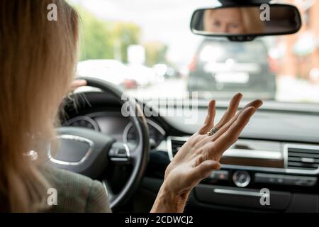 Mano di irritata e stanca donna d'affari bionda matura che esprime fastidio Foto Stock