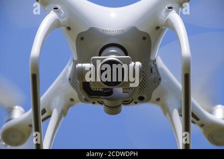 Drone DJI Phantom 4 in volo. Quadrocopter contro il cielo blu con nuvole bianche. Il volo del copter nel cielo. Foto Stock