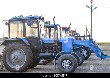 Trattore, in piedi in una fila. Macchine agricole. Foto Stock