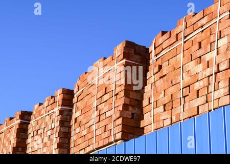 Rossi mattoni impilati in cubetti. Mattoni di magazzino. Stoccaggio prodotti laterizi Foto Stock