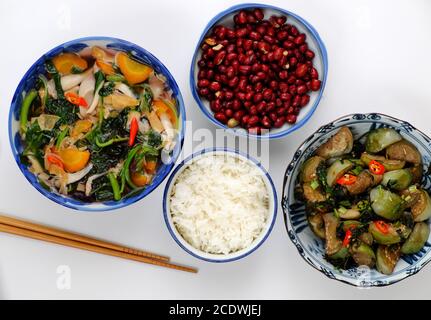 Pasto giornaliero vegano a pranzo, arachidi fritte con salsa, melanzane verdi fritte, ciotola di riso, zuppa di verdure, semplice cibo vegetariano vietnamita Foto Stock