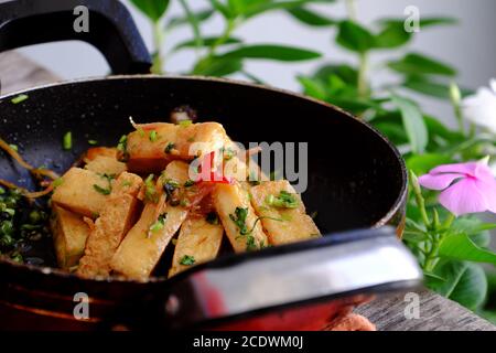 Piatto vegetariano vietnamita con vista alta, cuoco di tofu fritto con salsa e zenzero, semplice piatto vegano su padella, delizioso cibo fatto in casa pronto a mangiare Foto Stock