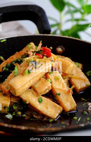 Piatto vegetariano vietnamita con vista alta, cuoco di tofu fritto con salsa e zenzero, semplice piatto vegano su padella, delizioso cibo fatto in casa pronto a mangiare Foto Stock