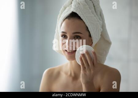 Primo piano donna sorridente pulizia pelle con spugna viso pulizia Foto Stock