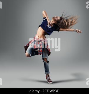 Moderno e giovane bellissima ballerina in posa su uno sfondo per studio Foto Stock