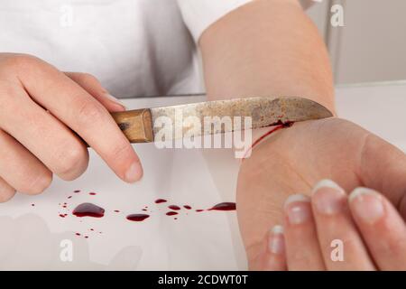 Tentativo di suicidio di una mano che taglia un polso con un coltello Foto Stock