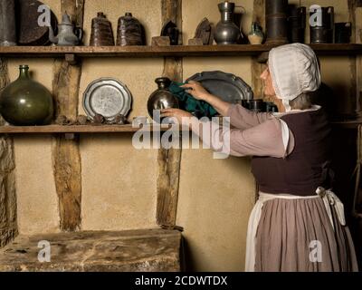 Donna vestita come un contadino medievale cameriera lavora in una cucina autentica in un castello francese Foto Stock