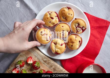 Pasticceria estiva fatta in casa - muffin alle fragole con frutti di bosco freschi su piatto bianco, piatto Foto Stock