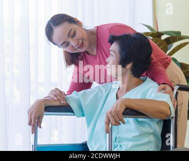 La famiglia asiatica, che è una madre malata, è in carrozzina, è ricoverata in ospedale e ha una figlia di cui prendersi cura. Foto Stock