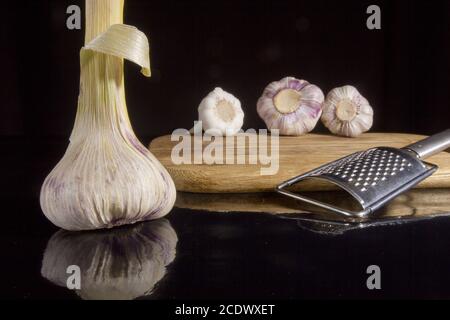 Teste di aglio e grattugia Foto Stock