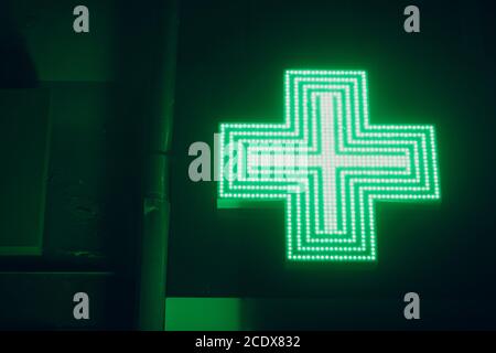 Croce verde segno su un edificio di farmacia Foto Stock