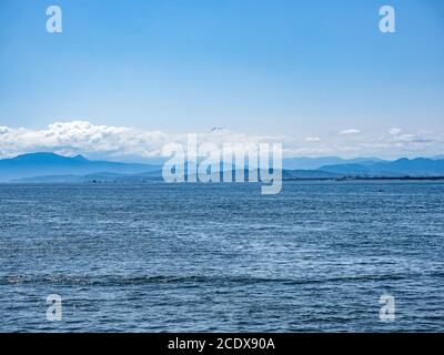 Guardando verso il Monte Fuji attraverso la Baia di Sagami dalla riva dell'isola di Enoshima a Fujisawa, Giappone. Foto Stock