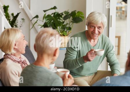 Gruppo di amici anziani che si riuniscono per bere il tè e. parlare a casa Foto Stock