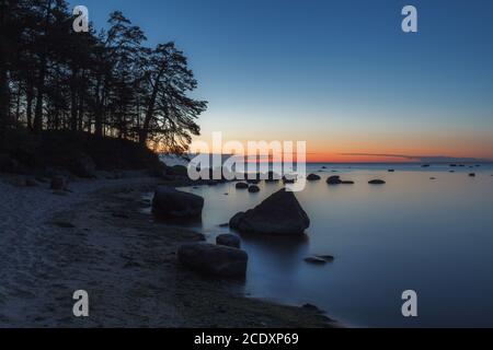 Mare e rocce al tramonto, cielo blu freddo. Composizione della natura. Foto Stock