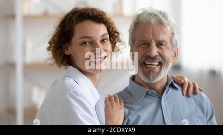 Ritratto della testa sorridente giovane infermiera e paziente maturo Foto Stock