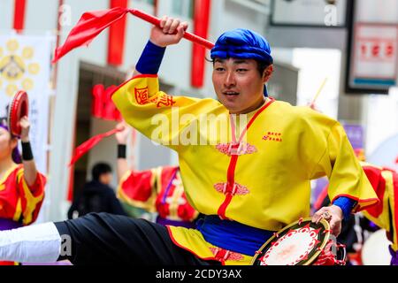 Primo piano del giovane ballerino giapponese yosakoi che tiene un tamburello mentre balla nel festival di danza Kyusyu Gassai a Kumamoto, Giappone. Foto Stock