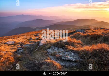 Panorama con interessante alba illumina i dintorni. Paesaggio con belle montagne e pietre. Fantastico scenario autunnale. Località turistica C Foto Stock