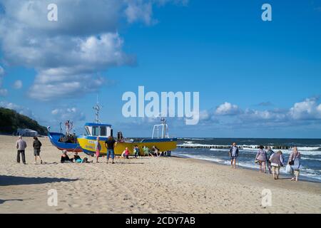 Turisti e barche da pesca sulla spiaggia di Rewal sulla costa polacca del Mar Baltico Foto Stock