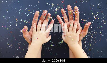 Mani di donna e capretto in confetti colorati Foto Stock