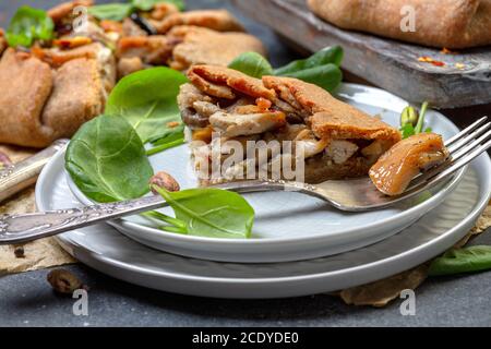 Pezzo di torta di segale con pollo, cipolle e funghi primo piano. Foto Stock