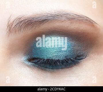 Macro shot closeup dell'occhio femminile chiuso. Ragazza con pelle perfetta e ombre blu degli occhi Foto Stock