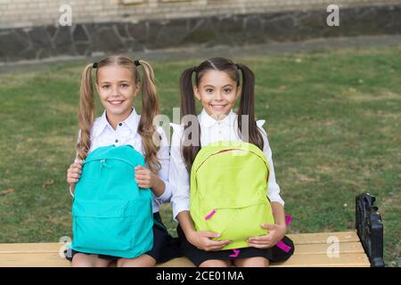 Studiare insieme per ottenere di più. Ragazze felici studiano nella scuola primaria. I bambini piccoli tengono le borse all'aperto. Studio a casa. Istruzione e scolarizzazione. Insegnamento privato. Ritorno a scuola. Dedicato allo studio. Foto Stock