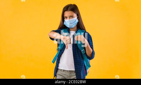 Triste ragazza adolescente mostrando pollici verso il basso gesto Foto Stock