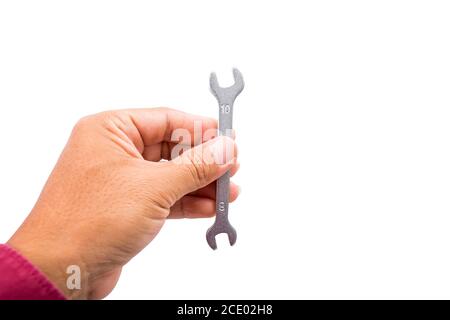 Una piccola chiave in metallo su fondo bianco a mano Foto Stock