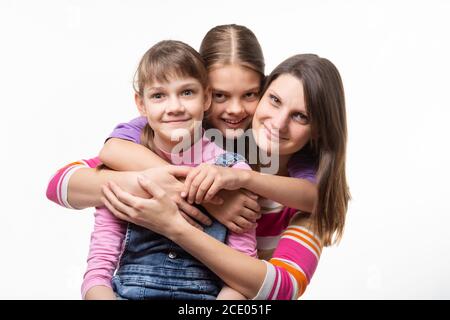 Due ragazze e una madre di aspetto europeo guardano felicemente alla cornice Foto Stock