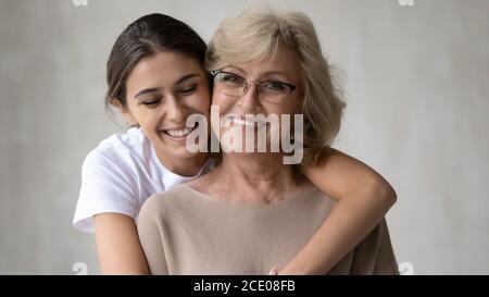 Sincero sorridente giovane donna coccolante felice metà anni 60 madre. Foto Stock